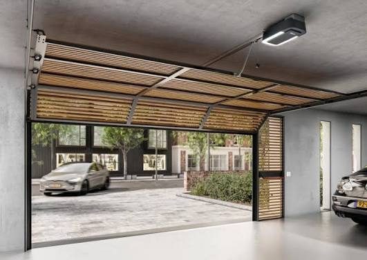 Garage door motor mounted above an open sectional garage door